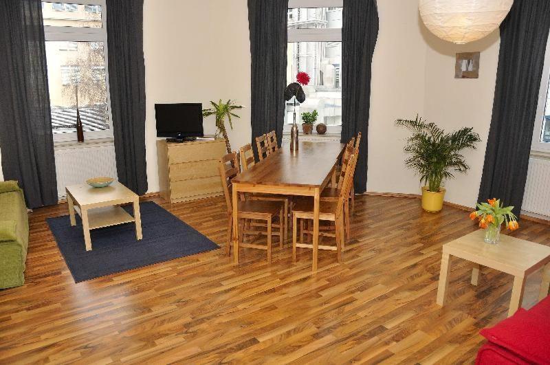 ein Wohnzimmer mit einem Holztisch und Stühlen in der Unterkunft Große Fewo Dresden Neustadt/Zentrum L9 in Dresden