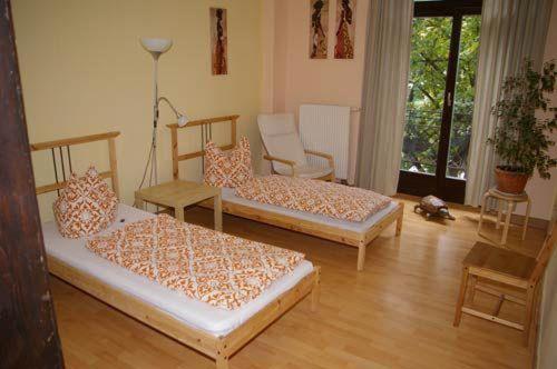 ein Wohnzimmer mit 2 Betten und einem Stuhl in der Unterkunft  3R Fewo bis 8 Personen zentral T8 in Dresden