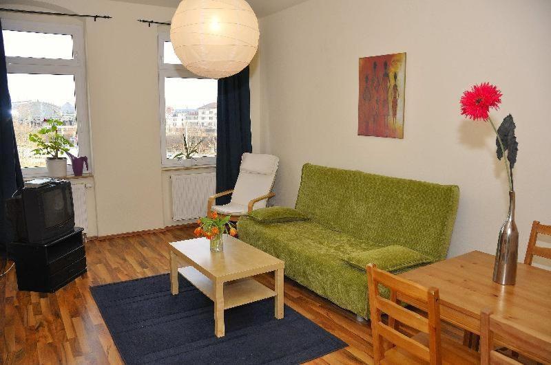 sala de estar con sofá verde y mesa en Dresden-Altstadt-Neustadt-3-Raum-Fewo-L11, en Dresden