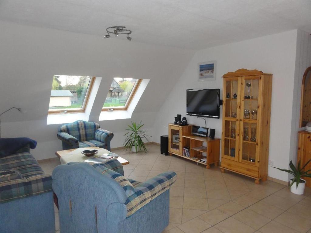 a living room with two blue chairs and a tv at Fewo-Kroeger in Lancken-Granitz