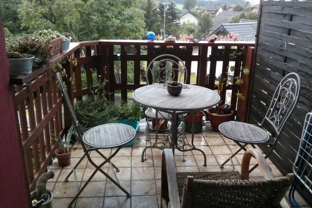 a patio with a table and chairs on a balcony at Ferienwohnungen-Willrich-Ferienwohnung-3 in Blankenheim