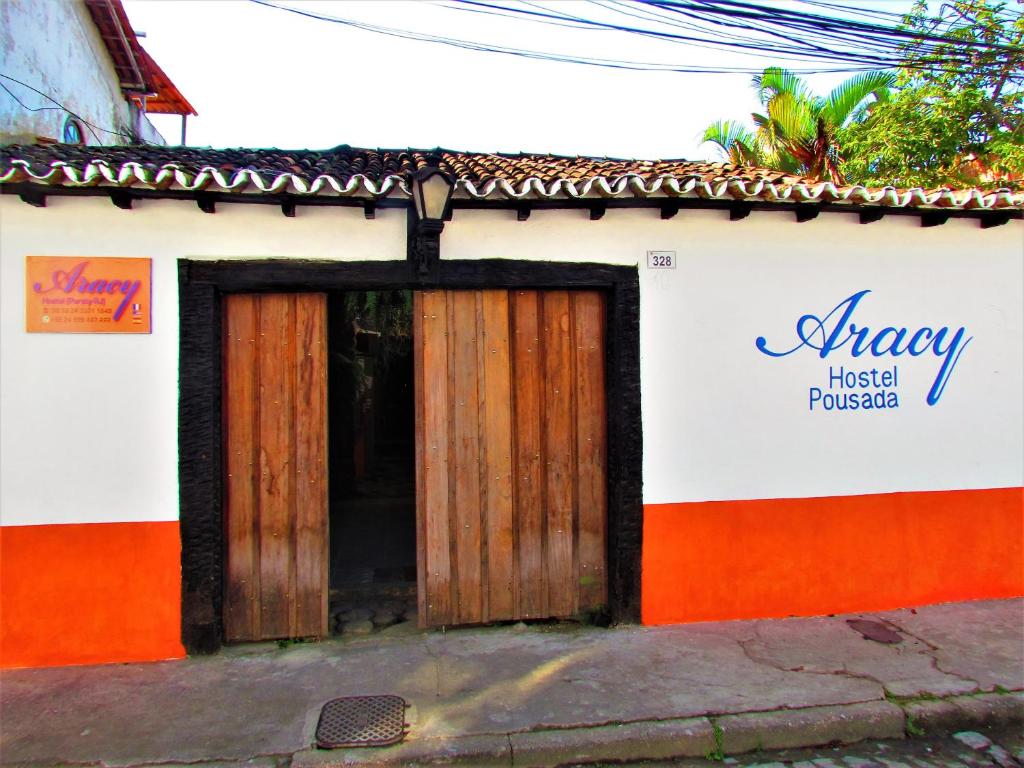 pomarańczowo-biały budynek z drewnianymi drzwiami w obiekcie Aracy Paraty w mieście Paraty