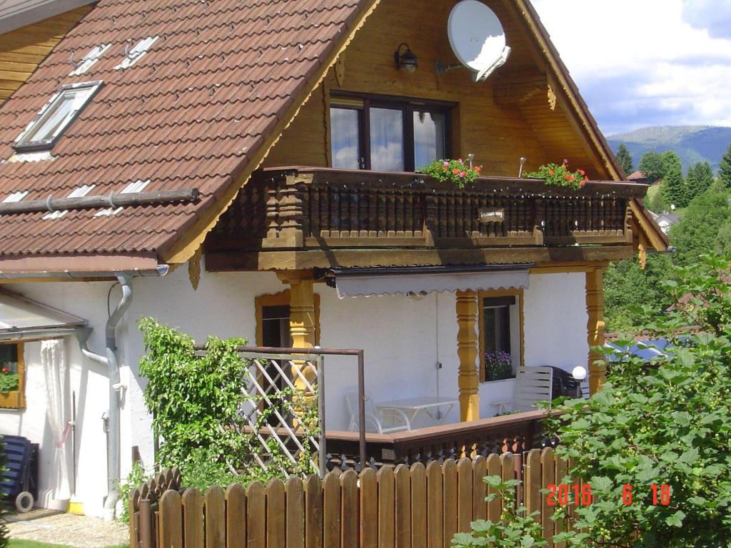 uma casa de madeira com uma varanda e uma cerca em Haus-Johanna em Riedlhütte