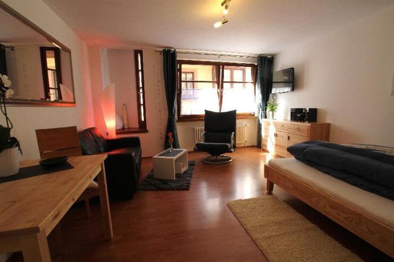 uma sala de estar com uma cama, uma mesa e cadeiras em Ferienwohnung-Konvikt-Nr-B em Freiburg im Breisgau