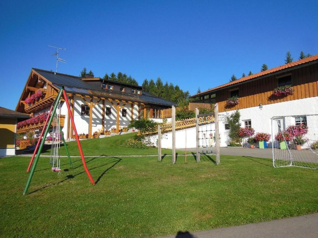 a playground in a yard in front of a building at Klausgupf in Neureichenau