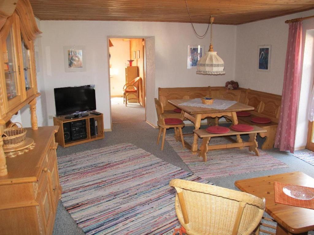 a living room with a table and a tv at Haus Haidweg Wohnung 4 in Haidmühle