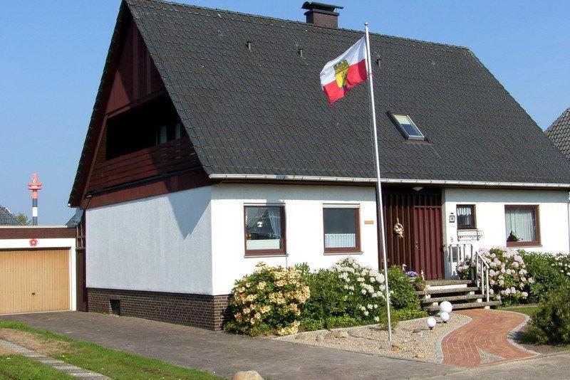 ein Haus mit einer Flagge davor in der Unterkunft Ferienwohnung "Sophia" in Cuxhaven