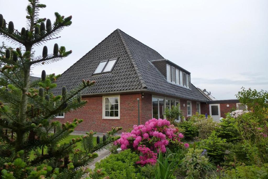 ein Haus mit rosa Blumen davor in der Unterkunft Haus Mueckenberger in Cuxhaven