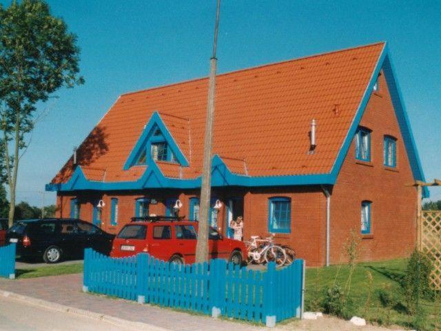 ein großes Haus mit einem blauen Zaun davor in der Unterkunft Zur alten Schmiede I Links in Boltenhagen