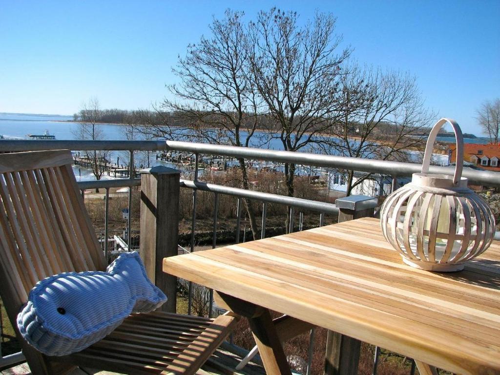 einen Holztisch auf einer Terrasse mit einem Wasserkocher in der Unterkunft Ferienwohnung Meeresblick Rerik in Rerik