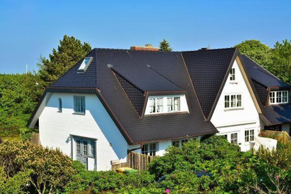 ein großes weißes Haus mit schwarzem Dach in der Unterkunft SYLT-FERIENHAUS für gehobene Ansprüche  in Erlangen