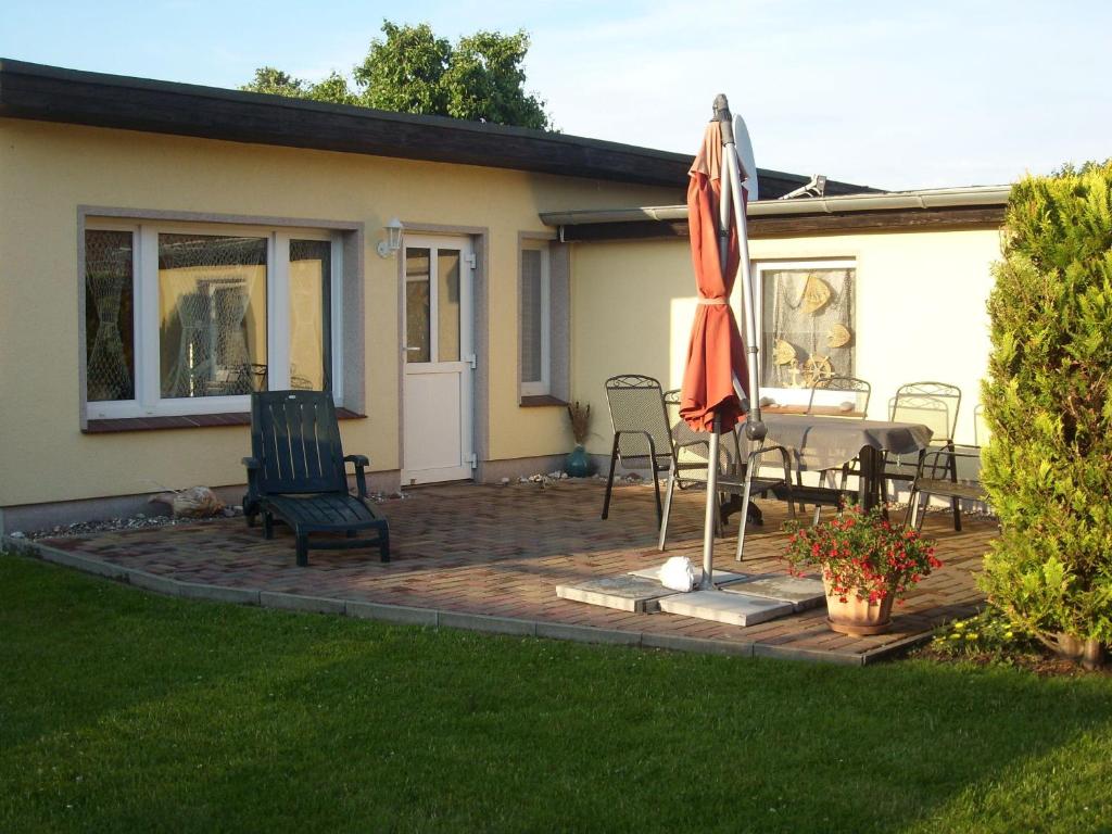 a patio with an umbrella and a table and chairs at Haus-J-Bull-das-Sonneneck-Ferienwohnung-an-der-schoenen-Ostsee-in-Boergerende-Rethwisch in Börgerende-Rethwisch