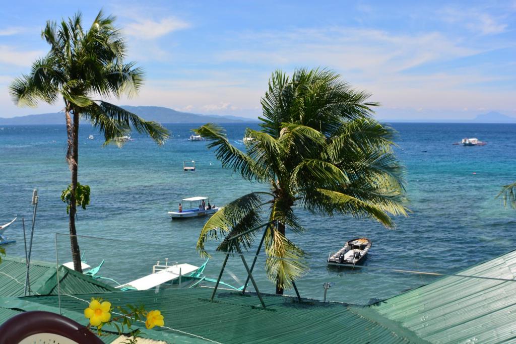 een uitzicht op de oceaan met boten in het water bij Captngreggs Dive Resort in Puerto Galera