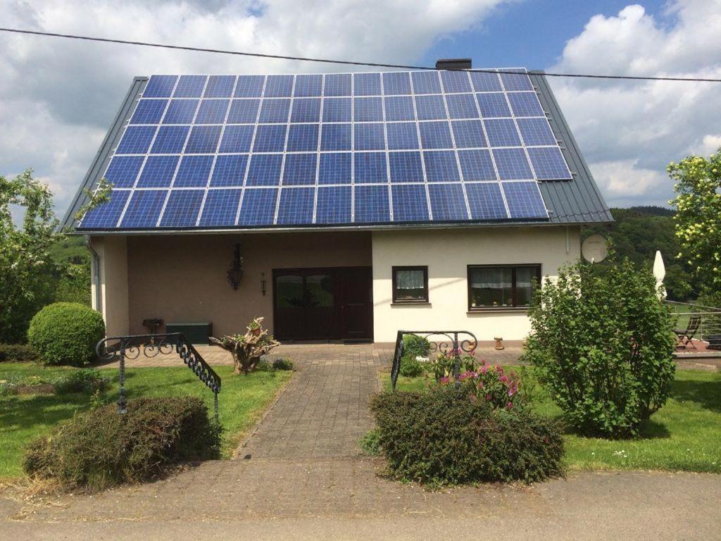 ein Haus mit vielen Sonnenkollektoren auf dem Dach in der Unterkunft Ferienwohnung Michels in Orlenbach