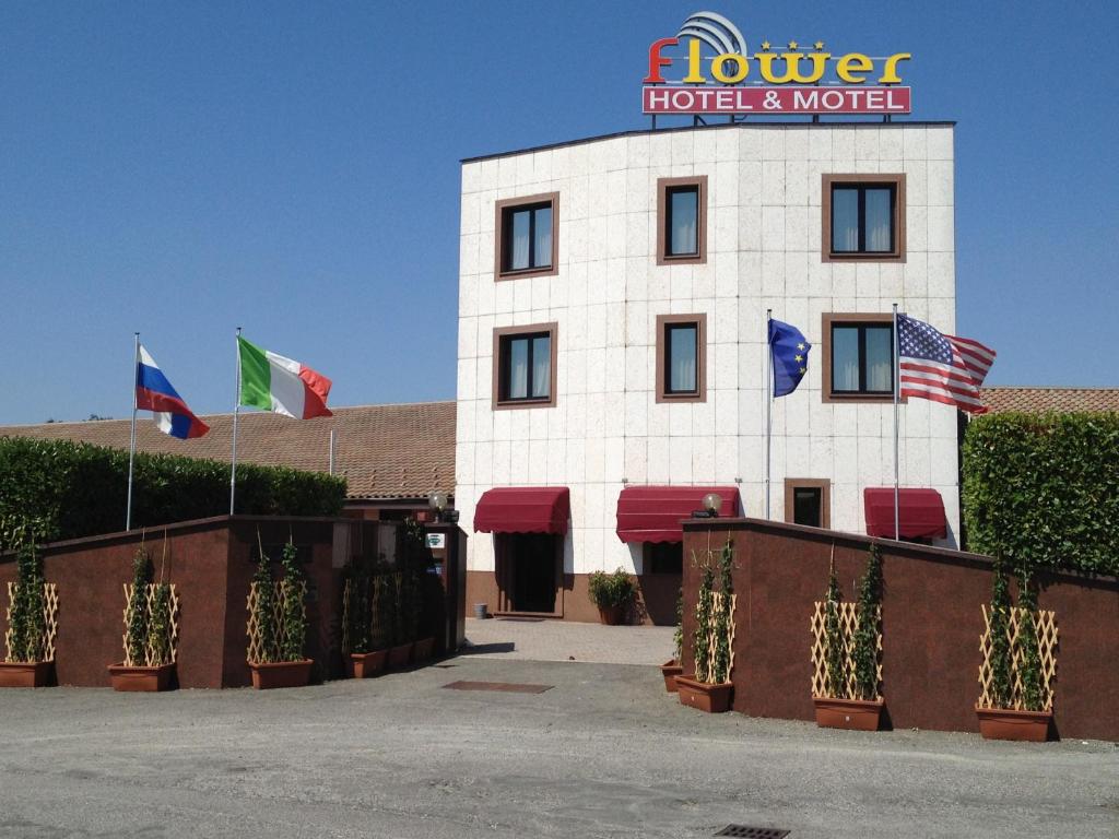 a hotel with flags in front of a building at Hotel Motel Flower in Novi Ligure