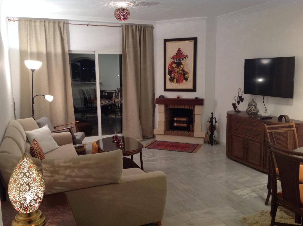 salon z kanapą i telewizorem w obiekcie 2 Bed penthouse, rooftop terrace, panoramic views w mieście Mijas