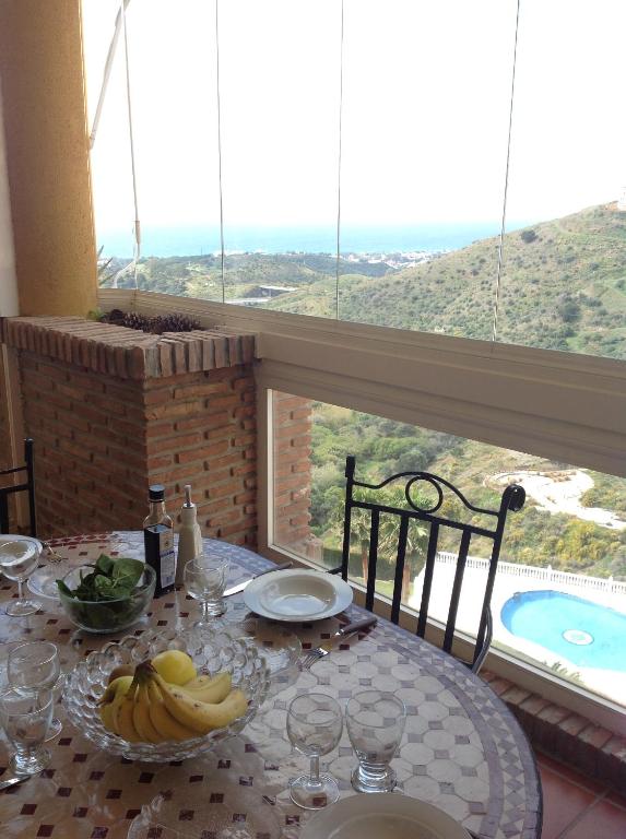 stół z talerzem bananów na stole z oknem w obiekcie 2 Bed penthouse, rooftop terrace, panoramic views w mieście Mijas