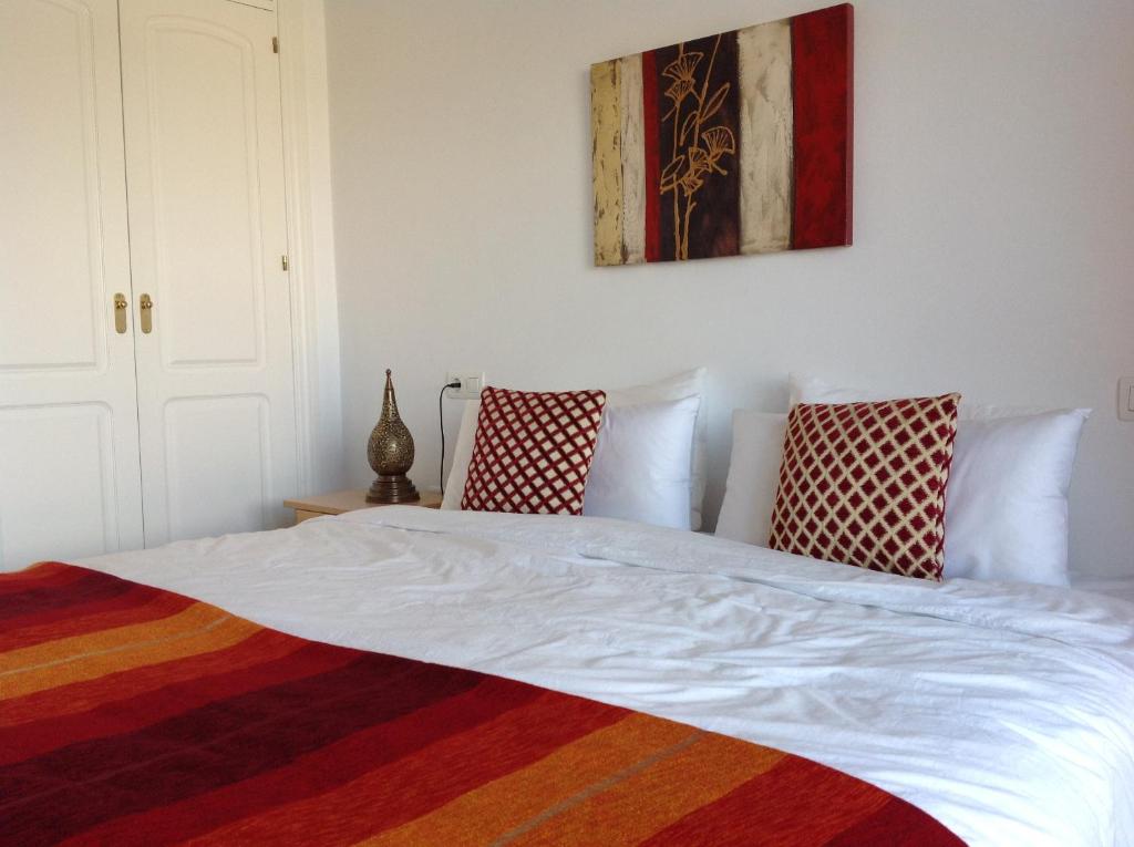 białe łóżko z 2 poduszkami w sypialni w obiekcie 2 Bed penthouse, rooftop terrace, panoramic views w mieście Mijas