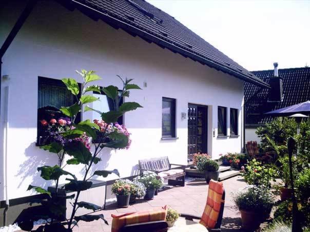 un patio con un banco y algunas plantas y flores en Apartment Jüngst, en Winterberg