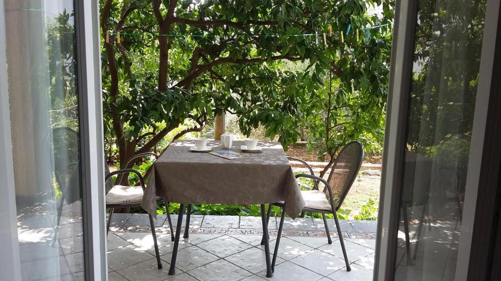 a table and chairs sitting on a patio with a window at Sobe Tonica in Krk