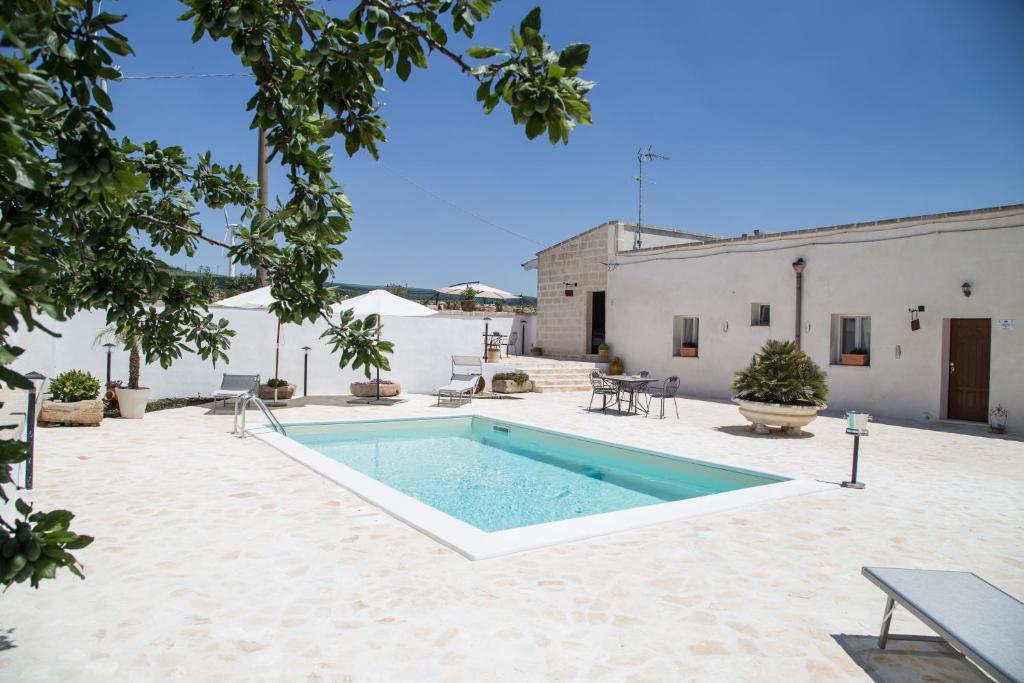 a pool in the middle of a courtyard with a building at Masseria 25 Anni in Laterza