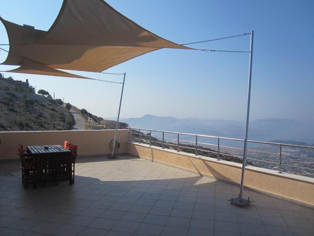 a balcony with a table and a view of the ocean at Viva B&B in Anavyssos