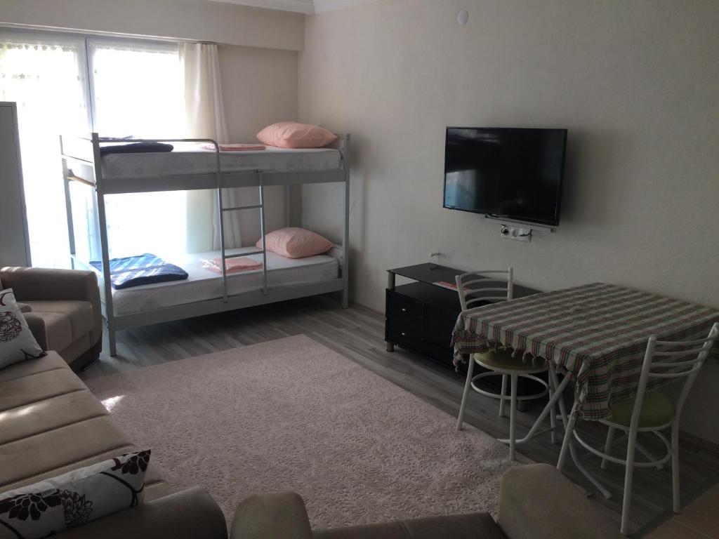 Gerze Apart Otel في غرزي: غرفة معيشة مع سريرين بطابقين وطاولة
