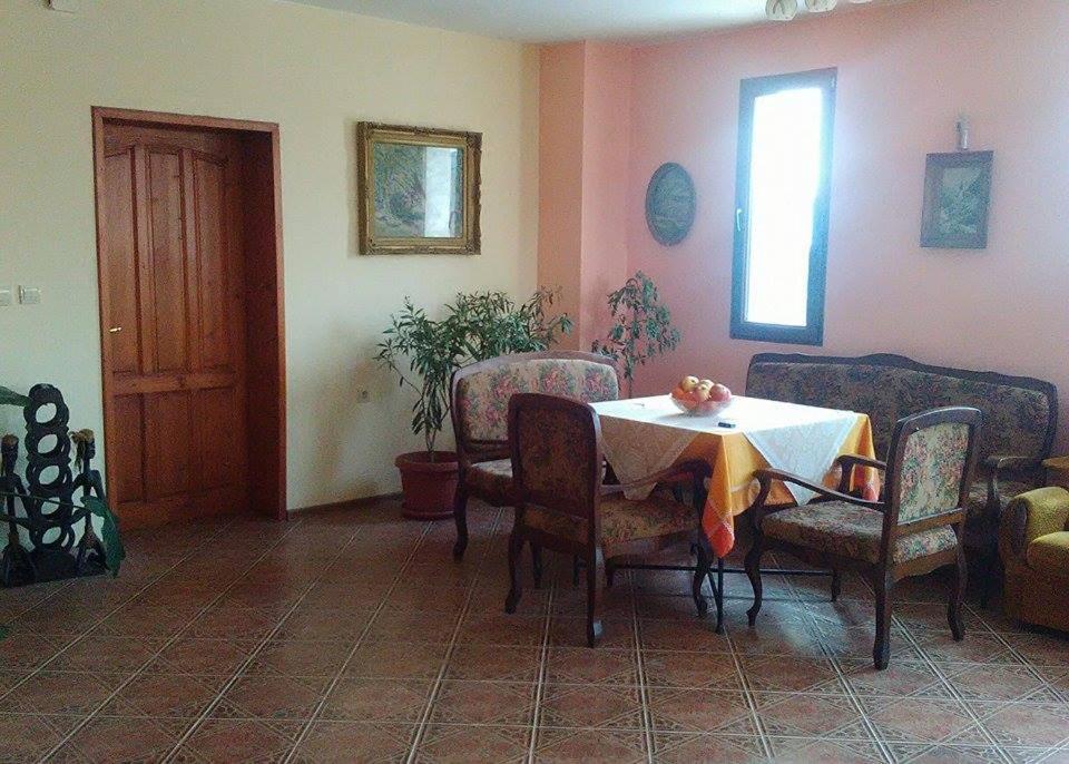 a dining room with a table and chairs and a window at Fenix Rooms in Arbanasi