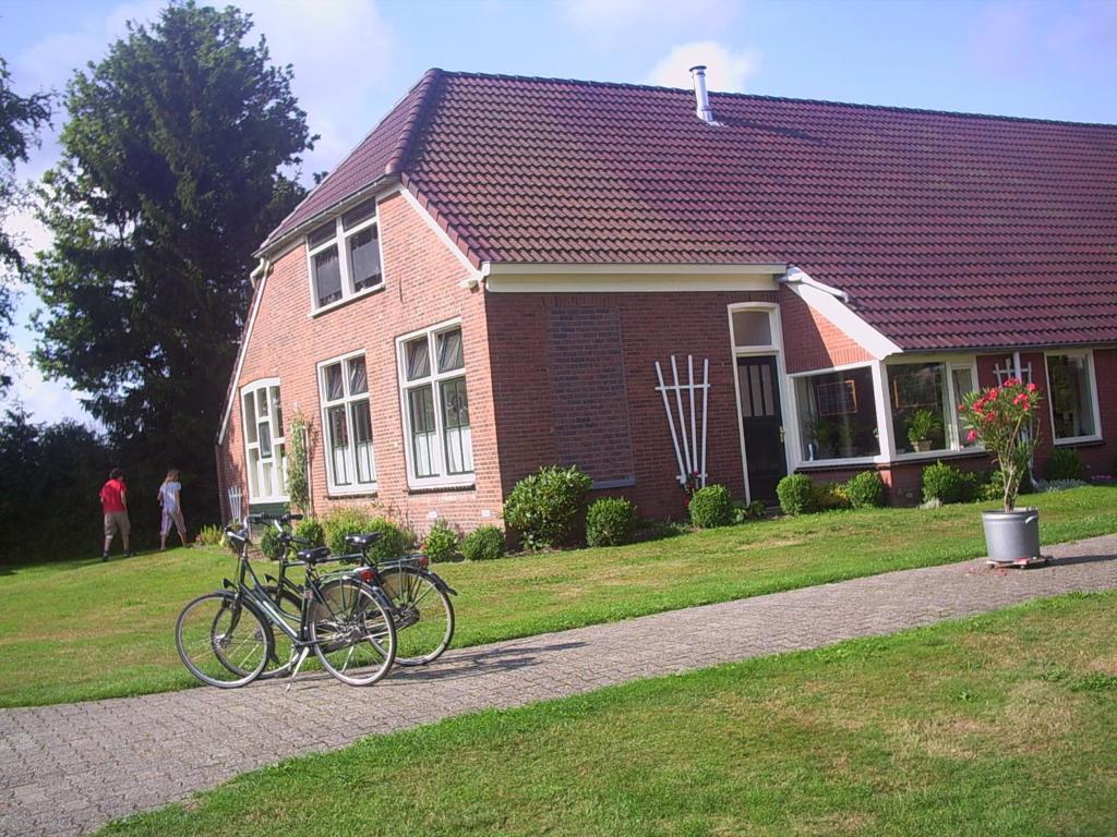 ein Haus mit zwei Fahrrädern davor geparkt in der Unterkunft Buitengoed Het Achterdiep in Ter Apel