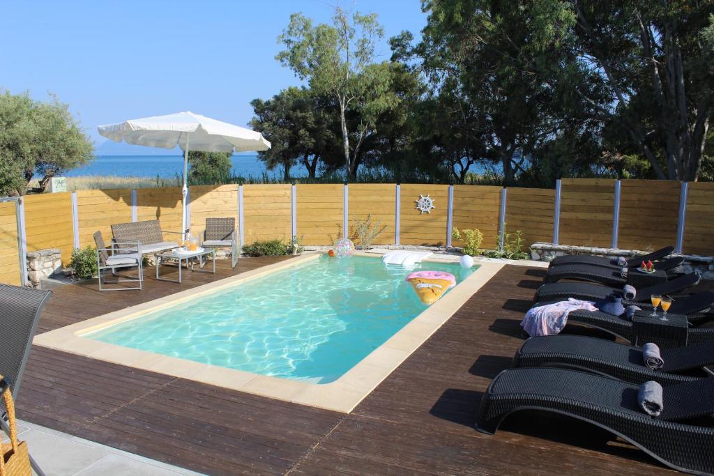 a swimming pool with lounge chairs and an umbrella at Onar Villa in Nikiana