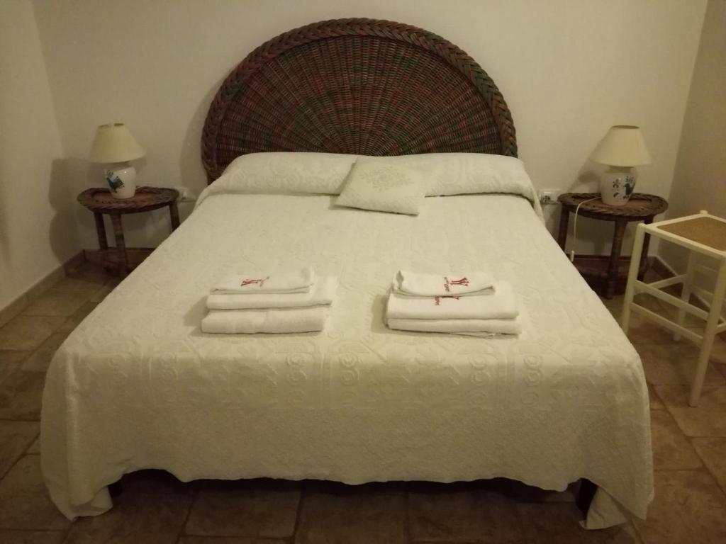 ブドーニにあるMelania Tanaunellaのベッドルーム1室(大型ベッド1台、タオル付)