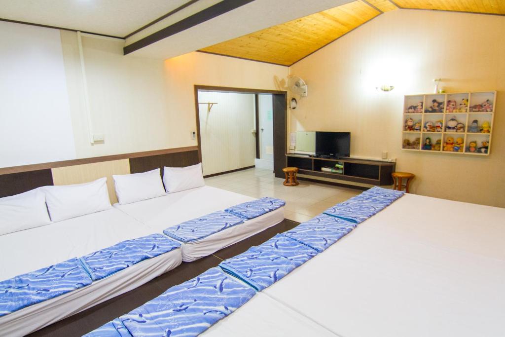 綠島鄉的住宿－綠邑民宿，配有电视的客房内的两张床