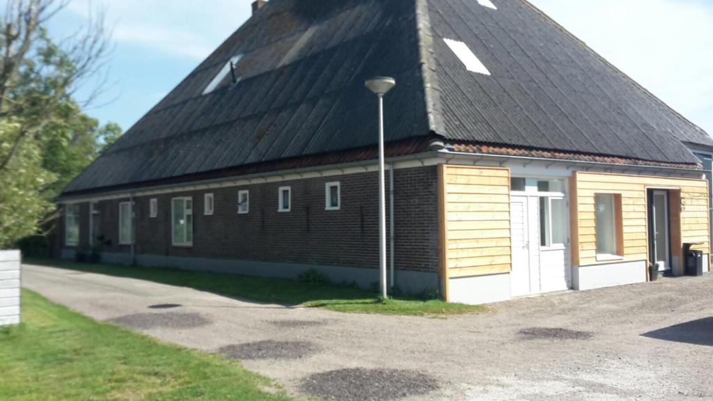 a large brick building with a black roof at Apartment Vredehof in Sint Maartensbrug