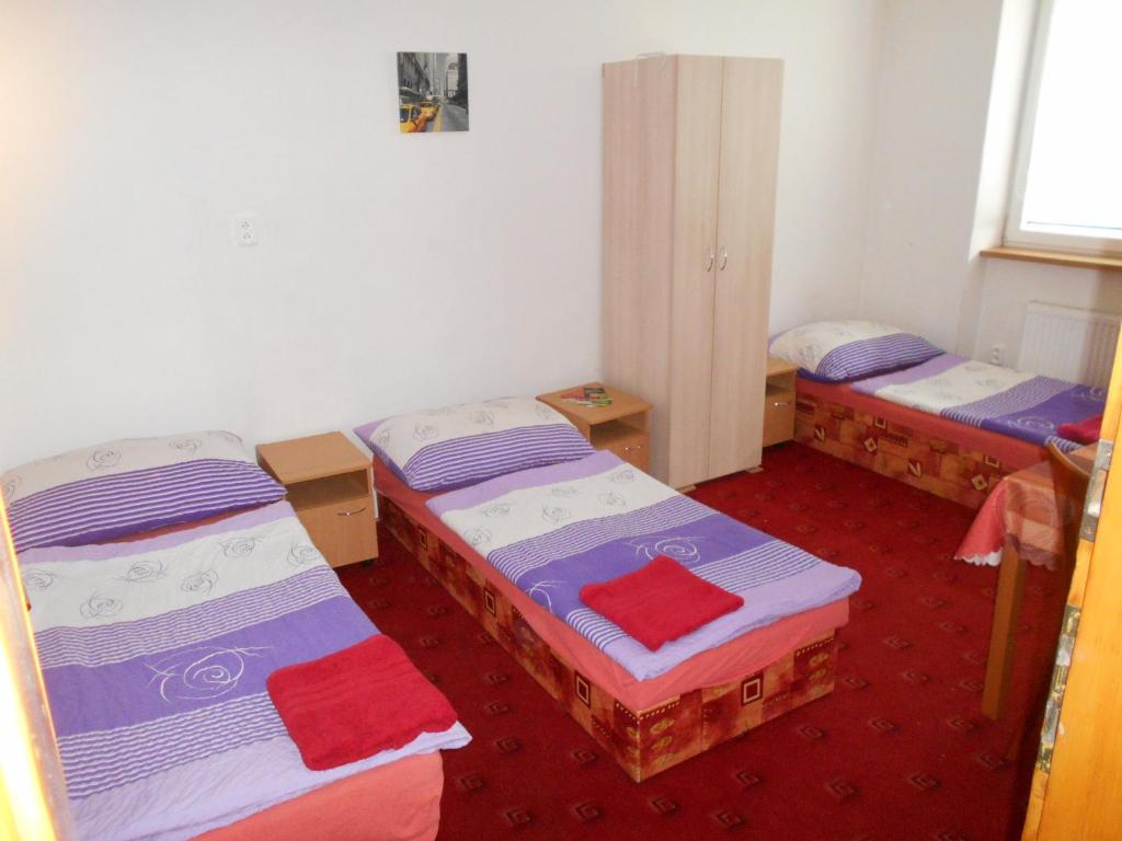 a room with three beds in a room at Penzion Apartmány Zlín in Zlín