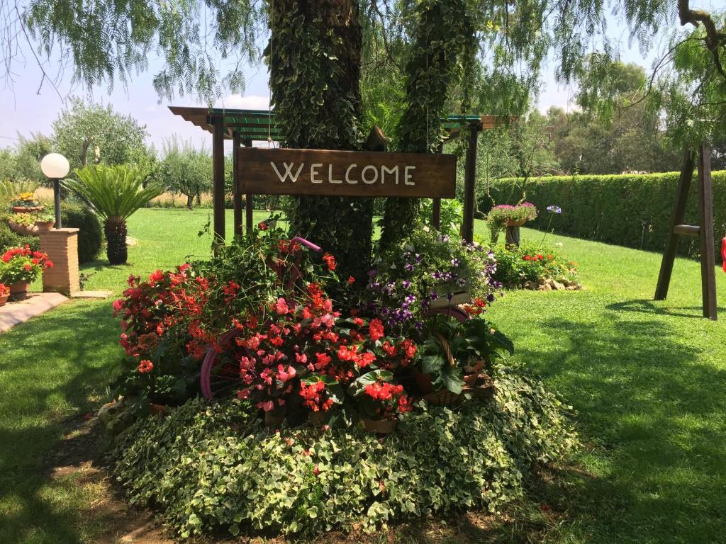 - un signe de bienvenue dans un jardin fleuri dans l'établissement Casale Del Borgo, à Hermada
