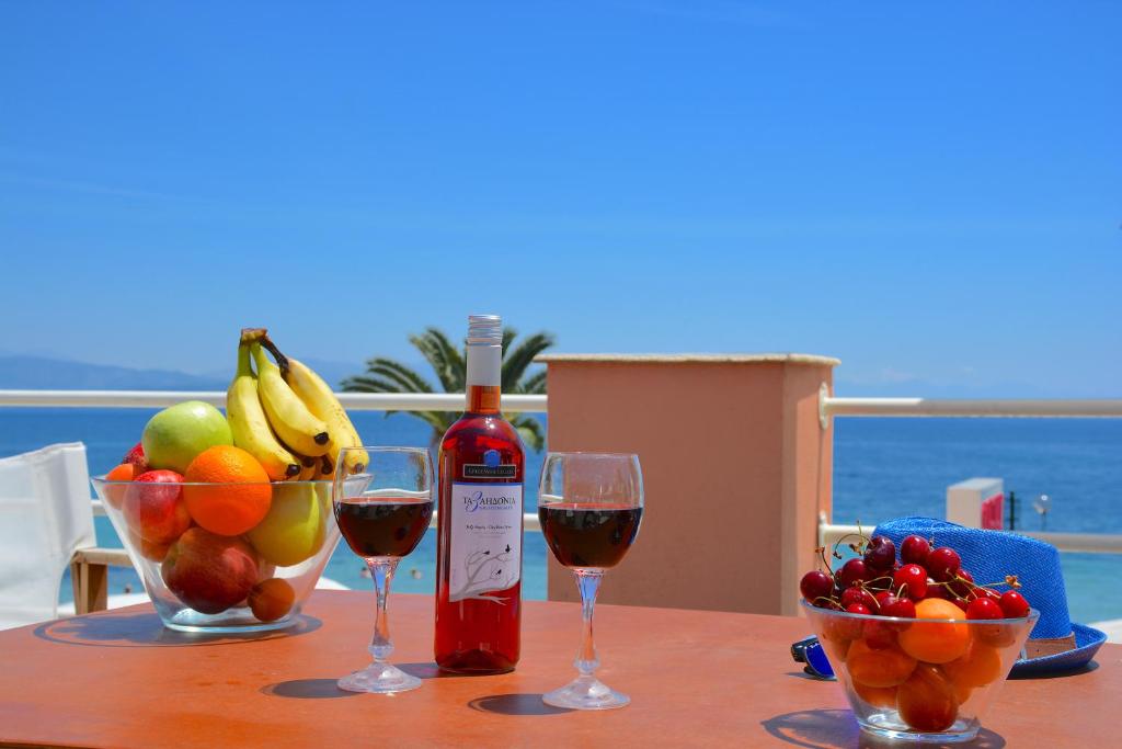 イプソスにあるAlexandra Apartmentのワイン2杯とフルーツ1杯付きのテーブル