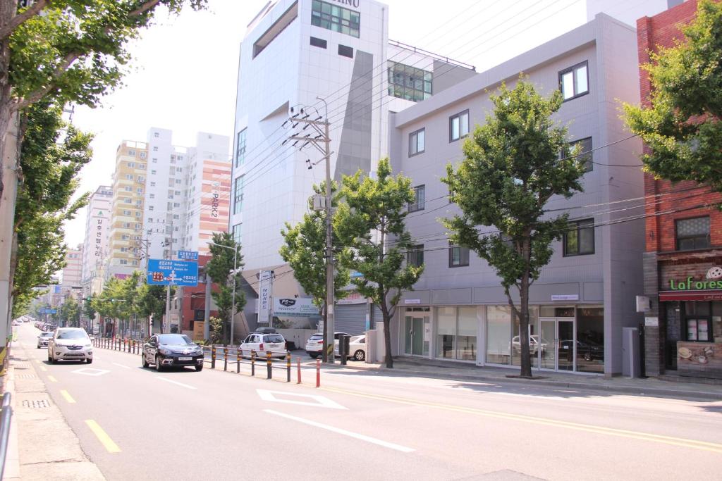 a city street with cars driving down the street at Wood House Hotel in Busan