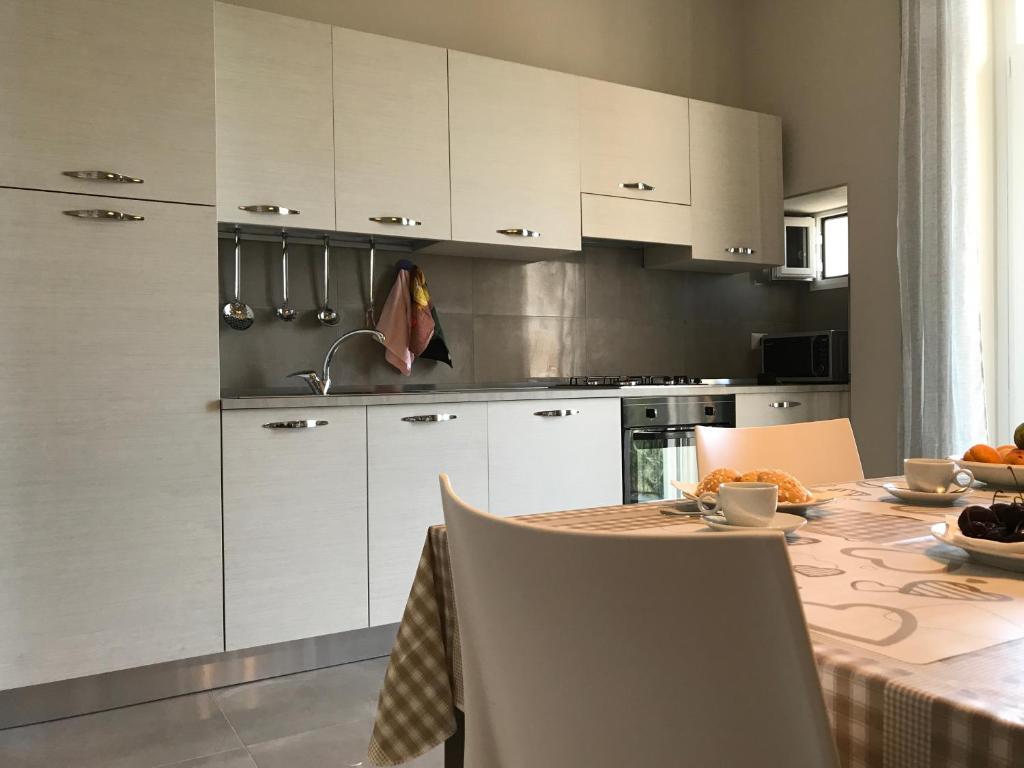 a kitchen with white cabinets and a table with food on it at Casa Vacanze La Scalinata in Bisceglie