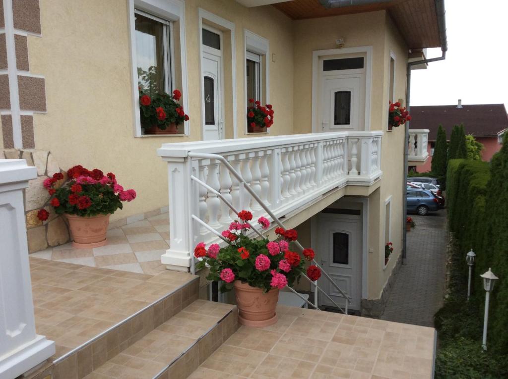 een huis met een trap met bloemen in potten bij József Apartments House in Zalakaros