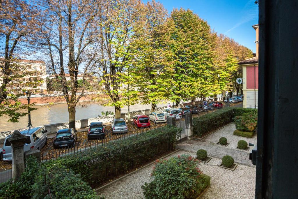 un grupo de coches estacionados en un estacionamiento junto a un río en Dimore Verona, en Verona