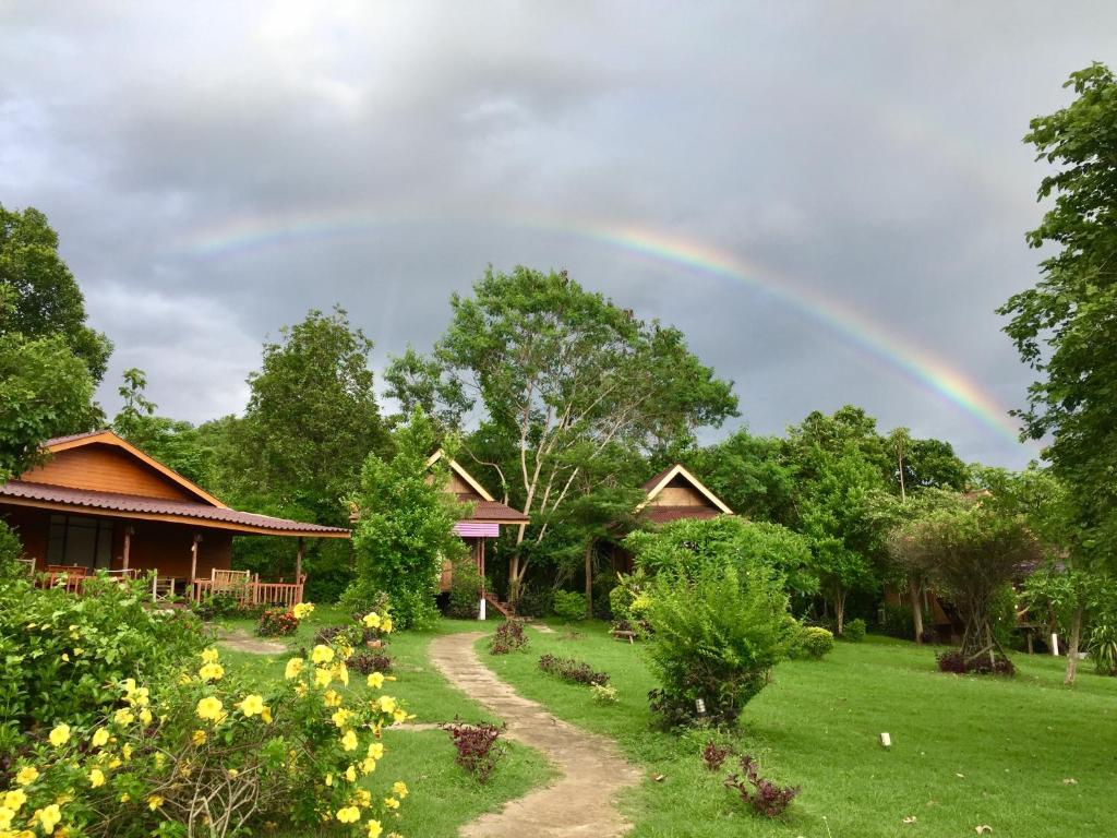 een regenboog in de lucht boven een huis bij Romantic Time Mountain Resort in Pai