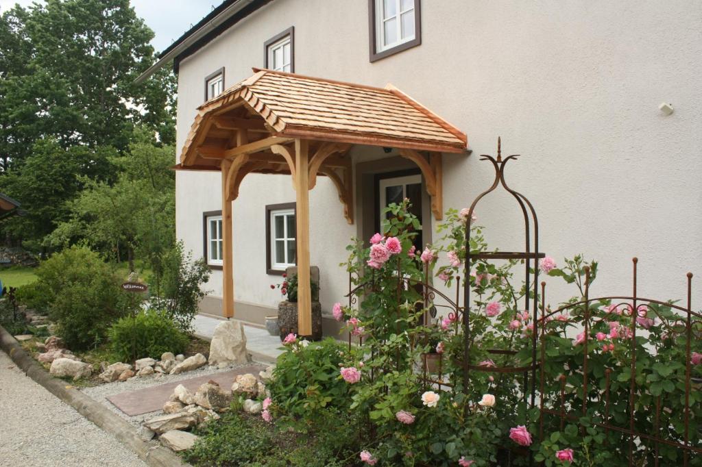 a gazebo in front of a house with roses at Landlust Ischl in Bad Ischl