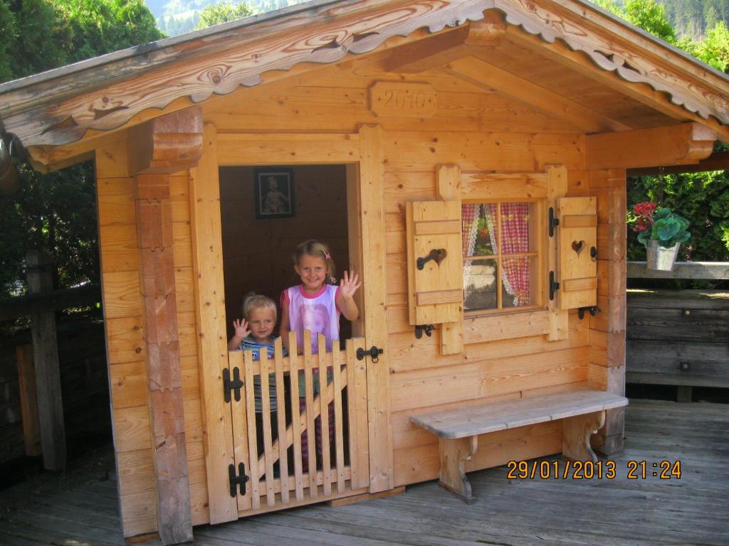 カルテンバッハにあるFerienwohnungen Juttaの木造犬小屋に立つ子供2人