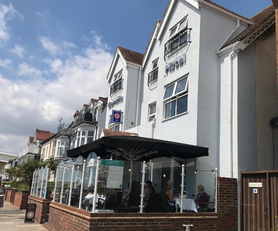 a white building with a restaurant in front of it at Camelia Hotel in Southend-on-Sea