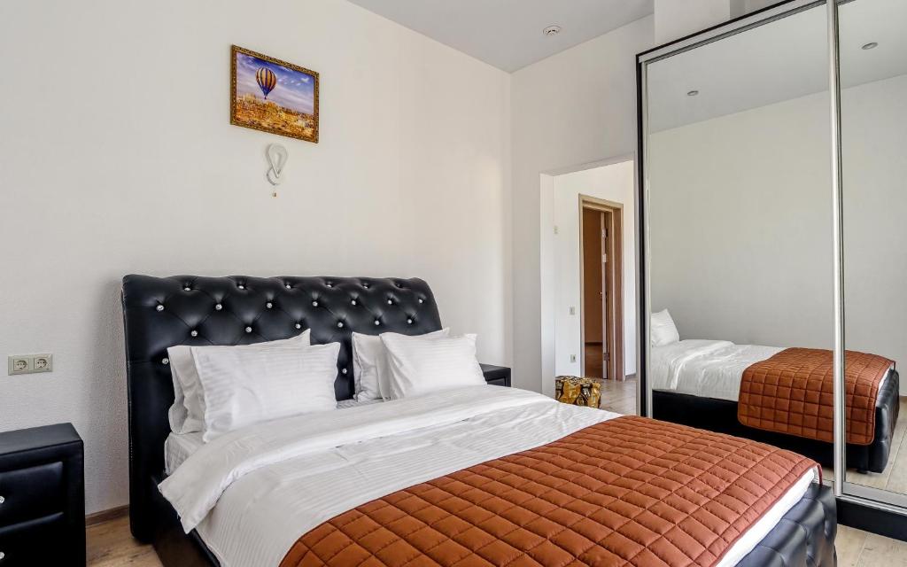 a bedroom with a large bed and a mirror at Hotel Sorrento in Odesa