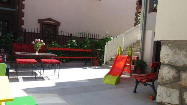 a patio with red and green chairs and a table at Guest House Stankovic in Soko Banja