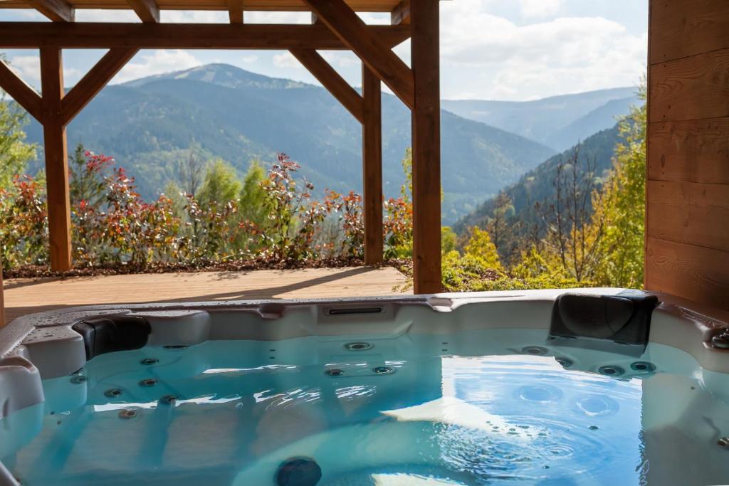 a jacuzzi tub with a view of mountains at La Cabane de Tim in Muhlbach-sur-Munster