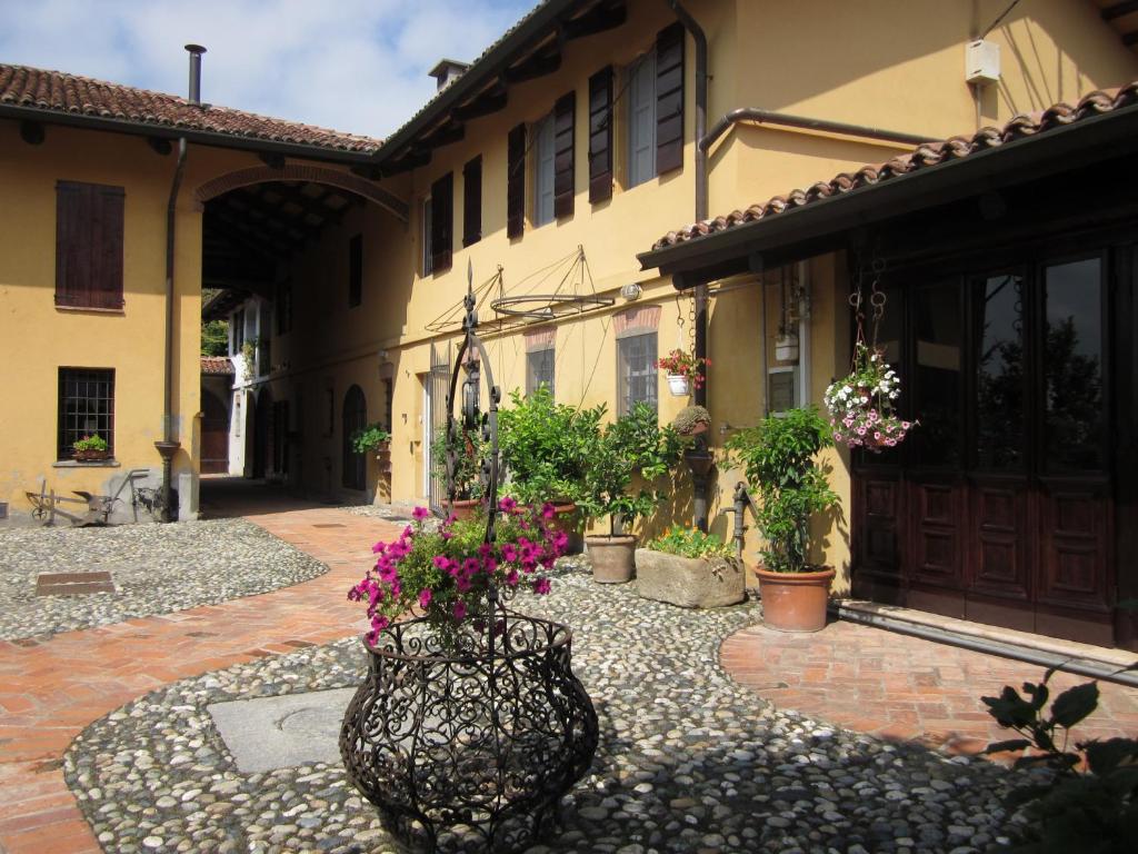 un patio de una casa con un jarrón lleno de flores en B&B AL BRIC, en San Raffaele Cimena