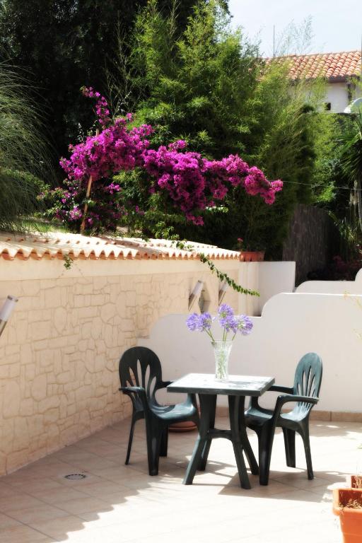 stół i krzesła z fioletowymi kwiatami na patio w obiekcie Bed And Breakfast casagalez w mieście Santa Domenica