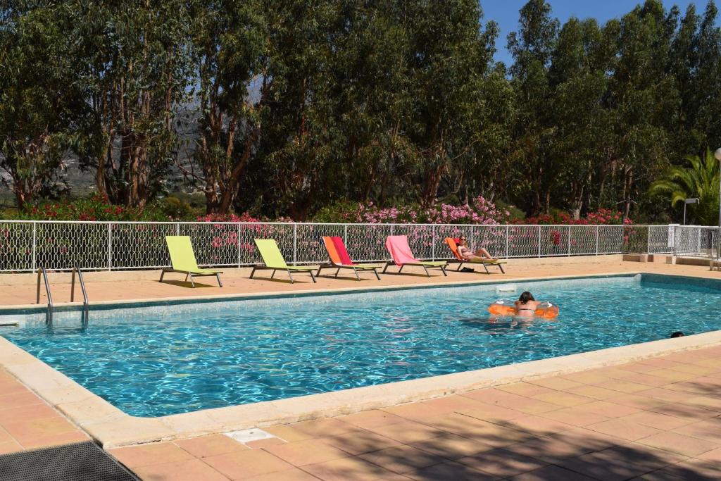 Un par de personas están en una piscina en Camping Paradella, en Calenzana